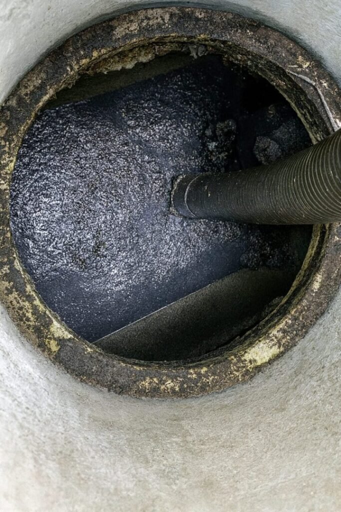 Pompage de fosse septique effectué par un technicien d’assainissement Pontoise, aspiration des boues et nettoyage complet du réservoir.